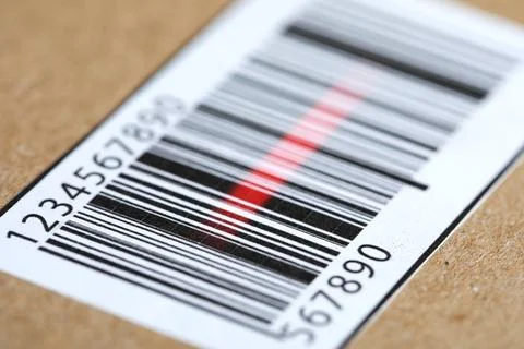 Parcel with label, closeup. Red laser light on barcode for scanning Stock Photos