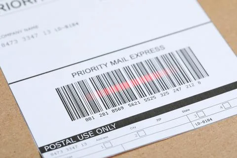 Parcel with label, closeup. Red laser light on barcode for scanning Photos
