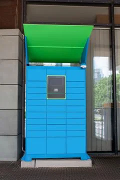 Parcel locker with many postal boxes near building outdoors Stock Photos