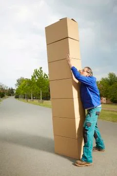 Parcel man with lot of paper boxes trying to move his delivery Photos