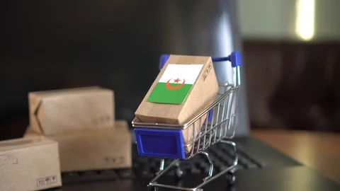 Parcel packaging box with a flag of Algeria in a shopping cart Video stock 102363252