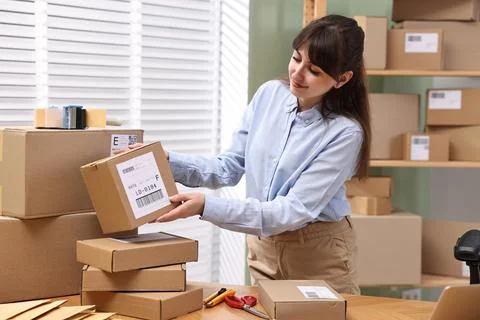 Parcel packing. Post office with parcels at wooden table indoors Stock Photos