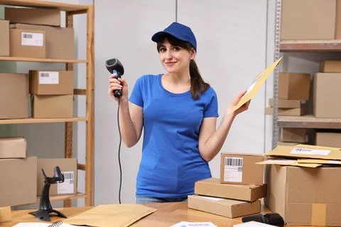 Parcel packing. Post office worker with barcode scanner and bag at wooden t.. Photos