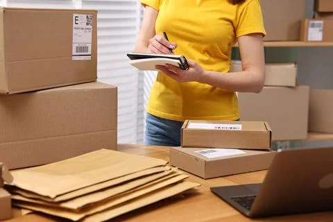 Parcel packing. Post office worker writing notes indoors, closeup Stock Photos