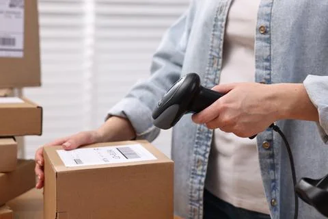 Parcel packing. Post office worker with scanner reading barcode indoors, cl.. Foto stock