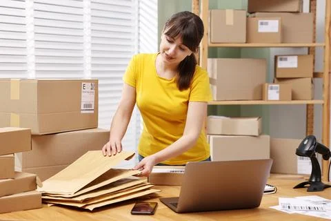 Parcel packing. Post office worker with parcels at wooden table indoors Photos