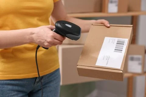 Parcel packing. Post office worker with scanner reading barcode indoors, cl.. Photos