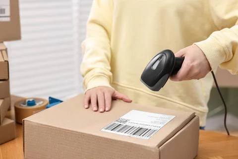 Parcel packing. Post office worker with scanner reading barcode indoors, cl.. Photos