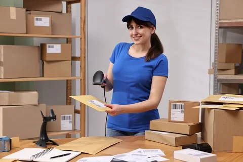 Parcel packing. Post office worker with scanner reading barcode at wooden t.. Photos