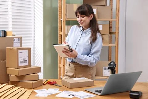 Parcel packing. Post office worker writing notes indoors Stock Photos
