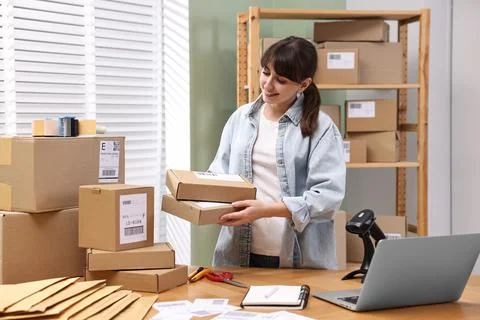Parcel packing. Post office worker with parcels at wooden table indoors Photos