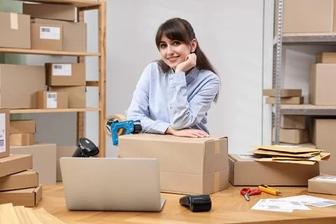 Parcel packing. Post office worker with box at wooden table indoors Foto stock