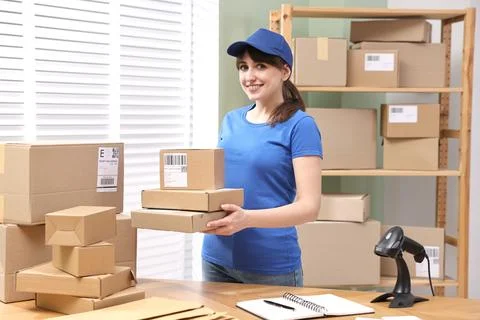 Parcel packing. Post office worker with parcels at wooden table indoors Photos