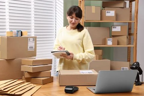 Parcel packing. Post office worker writing notes indoors Stock Photos