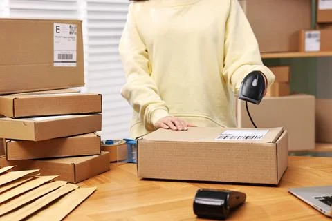 Parcel packing. Post office worker with scanner reading barcode indoors, cl.. Photos