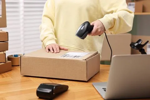 Parcel packing. Post office worker with scanner reading barcode indoors, cl.. Foto stock