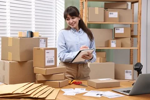 Parcel packing. Post office worker writing notes indoors Stock Photos