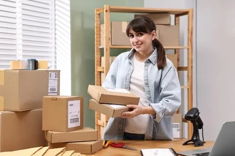 Parcel packing. Post office worker with parcels at wooden table indoors Photos