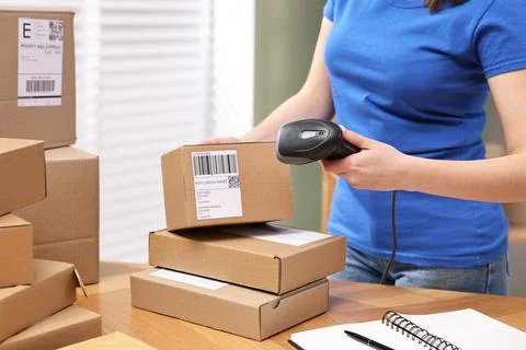 Parcel packing. Post office worker with scanner reading barcode indoors, cl.. Photos