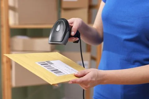 Parcel packing. Post office worker with scanner reading barcode indoors, cl.. Photos
