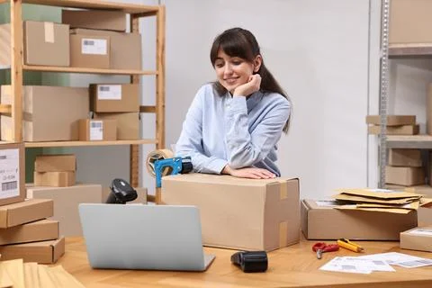 Parcel packing. Post office worker with box at wooden table indoors Foto stock