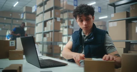 Parcel processing specialist scans packages, prepares for shipping to customers Stock Footage 307578280