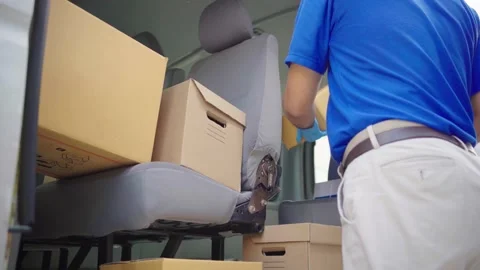 Parcel staff arranges parcels on the car and deliver them to the customer. Stock Footage 149805046