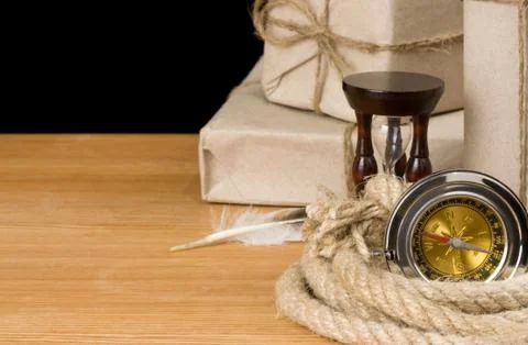 Parcel wrapped and compass on black Stock Photos