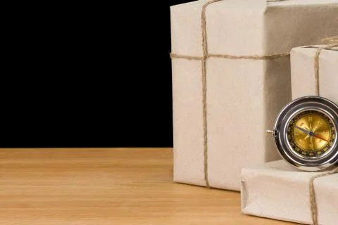 Parcel wrapped and compass isolated on black Stock Photos