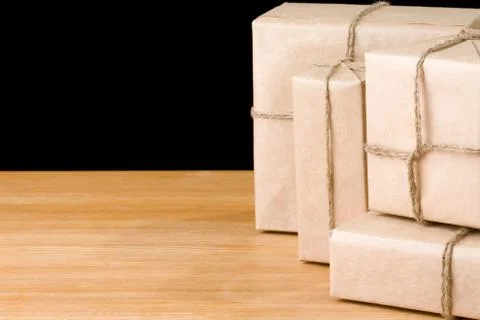 Parcel wrapped packaged box isolated on black Stock Photos