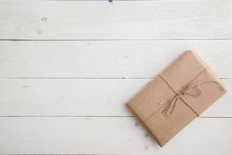 Parcel,gift Packed in eco-friendly paper on light wooden background. the v... Stock Photos