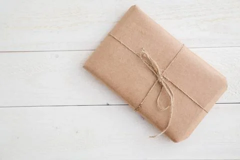 Parcel,gift Packed in eco-friendly paper on light wooden background. the v... 스톡 사진