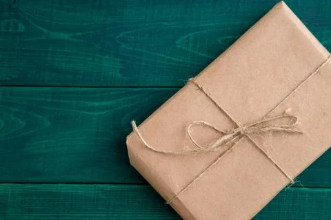 Parcel,gift Packed in eco-friendly paper on dark green wooden background. ... Stock Photos