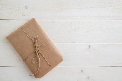 Parcel,gift Packed in eco-friendly paper on light wooden background. the v... 스톡 사진