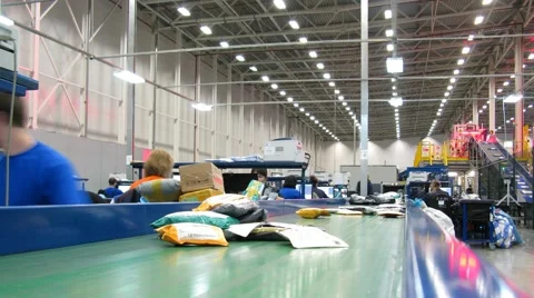 Parcels are moving through the conveyor, workers work beside tables Video stock 58284749
