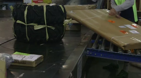 Parcels being sorted on a carousel in a freight warehouse by a male Stock Footage 41315988