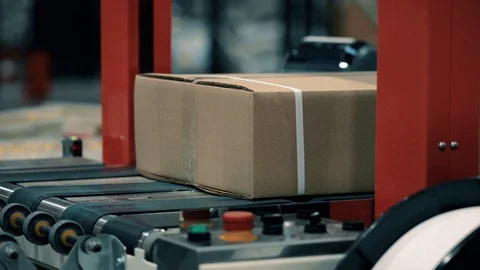 Parcels in a warehouse with cardboard box moving along the packaging line. Plast Stock Footage 128295511