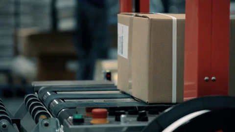 Parcels in a warehouse move along and wait in line the packaging line. Plastic s 스톡 동영상 128295512