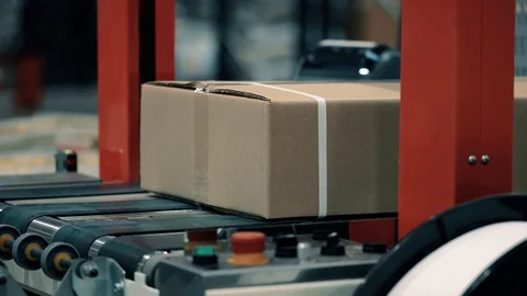 Parcels in a warehouse move along and wait in line the packaging line. Plastic s Video stock 128295514