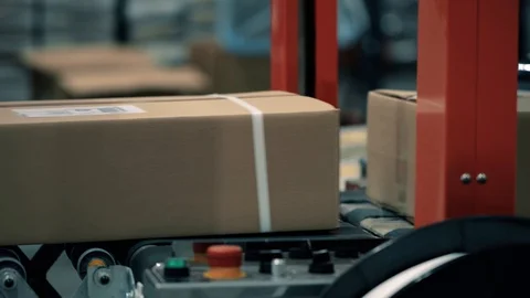 Parcels in a warehouse move along and wait in line the packaging line. Plastic s Stock Footage 128295610