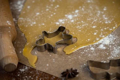 On the parchment there is a carver in the form of a man near the rolled dough Stock Photos