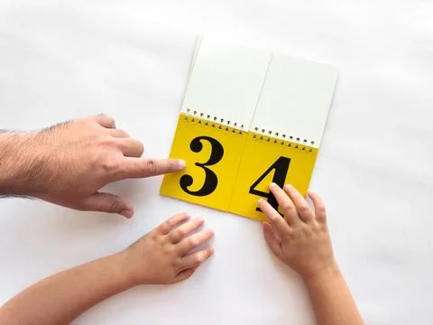 Parent and child learning numbers together with a yellow flip book Stock-Fotos