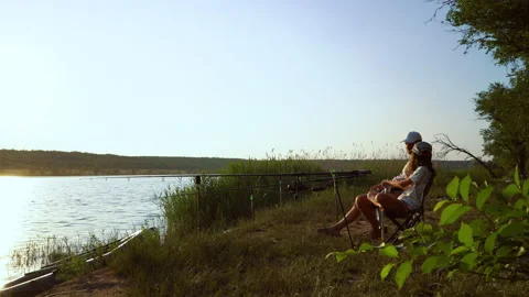 Parent and child spending time together fishing on river bank Stock Footage 135027880
