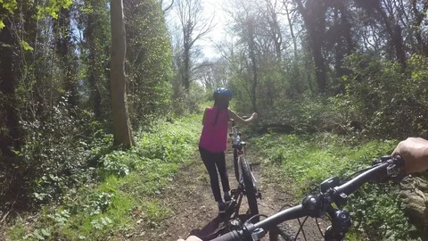 Parent and child walking through a forest with their mountain bikes, in fpv Video stock 74264590
