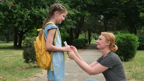 Parent and pupil of elementary school. Mom and girl with backpack behind back Stock Footage 198372794