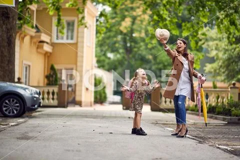 Parent and pupil of primary school. Woman and girl with backpack. Beginning o Stock Photos