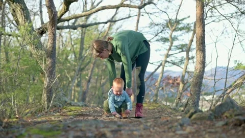 A parent and toddler engaged in exploring a forest path, emphasizing curiosity Stock Footage 278186973