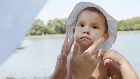 Parent applying cream on child Stock Footage 77559984