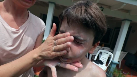 Parent applying sunblock to child face. Mother applies sunscreen to kid Stock Footage 126163943
