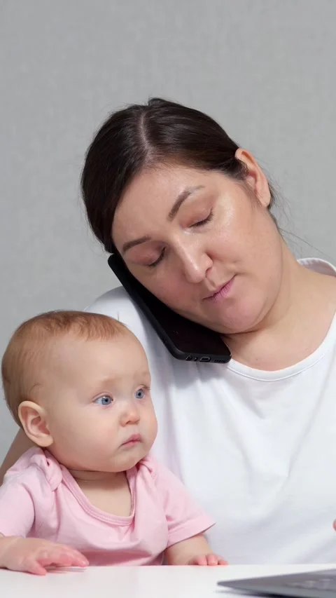 Parent Balances Office Work With Child Care Indoors. Adult Female Talks On Stock Footage 346764860